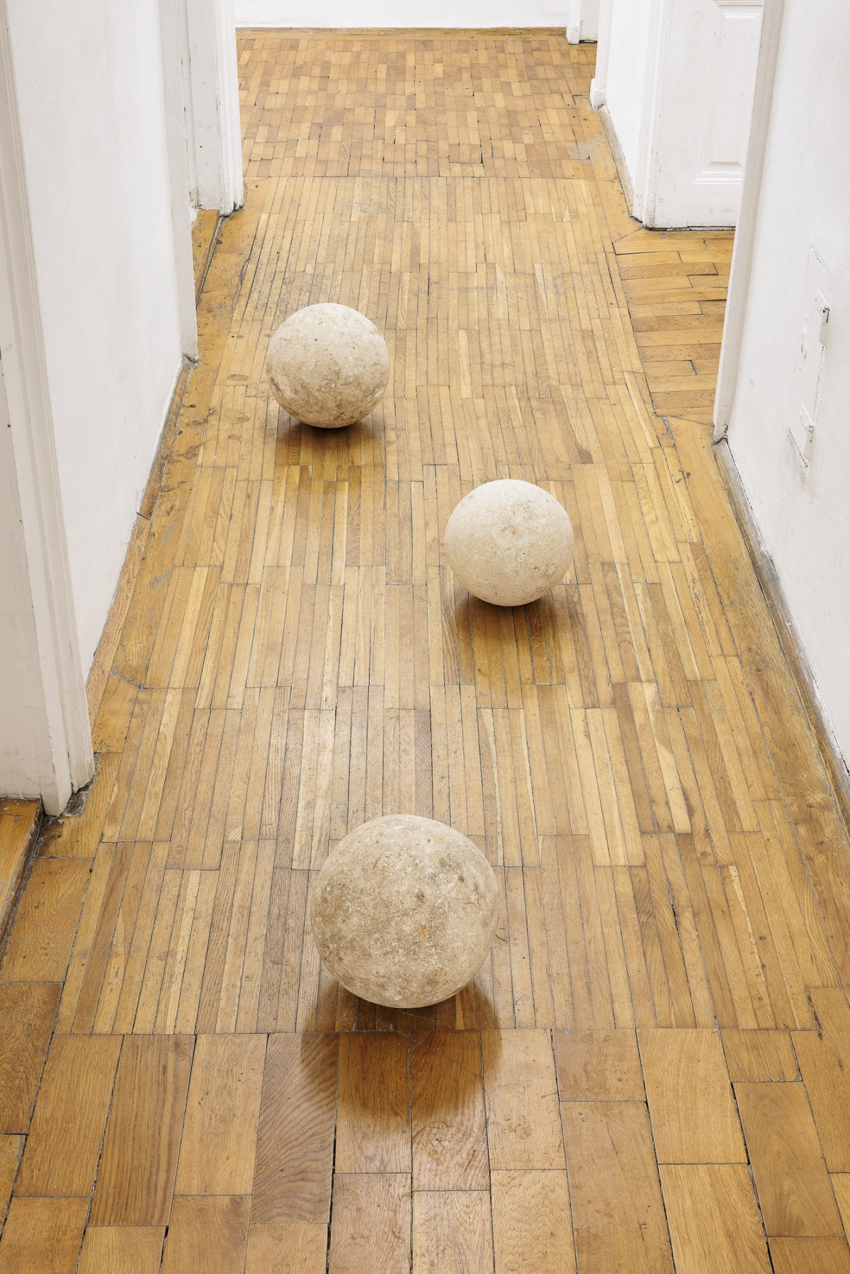 Vue d'exposition, « Above, Below, Between », John M Armleder, Untilted, 1985, trois sculptures en pierre mesurant respectivement 25 cm, 23 cm et 21 cm de diamètre, CALM – Centre d’Art La Meute invité par UA26, Vienne, Autriche, 2026 / Photo ©kunst-dokumentation.com / Manuel Carreon Lopez / Courtoisie de l'artiste / Curaté par Oriane Emery & Jean- Rodolphe Petter.